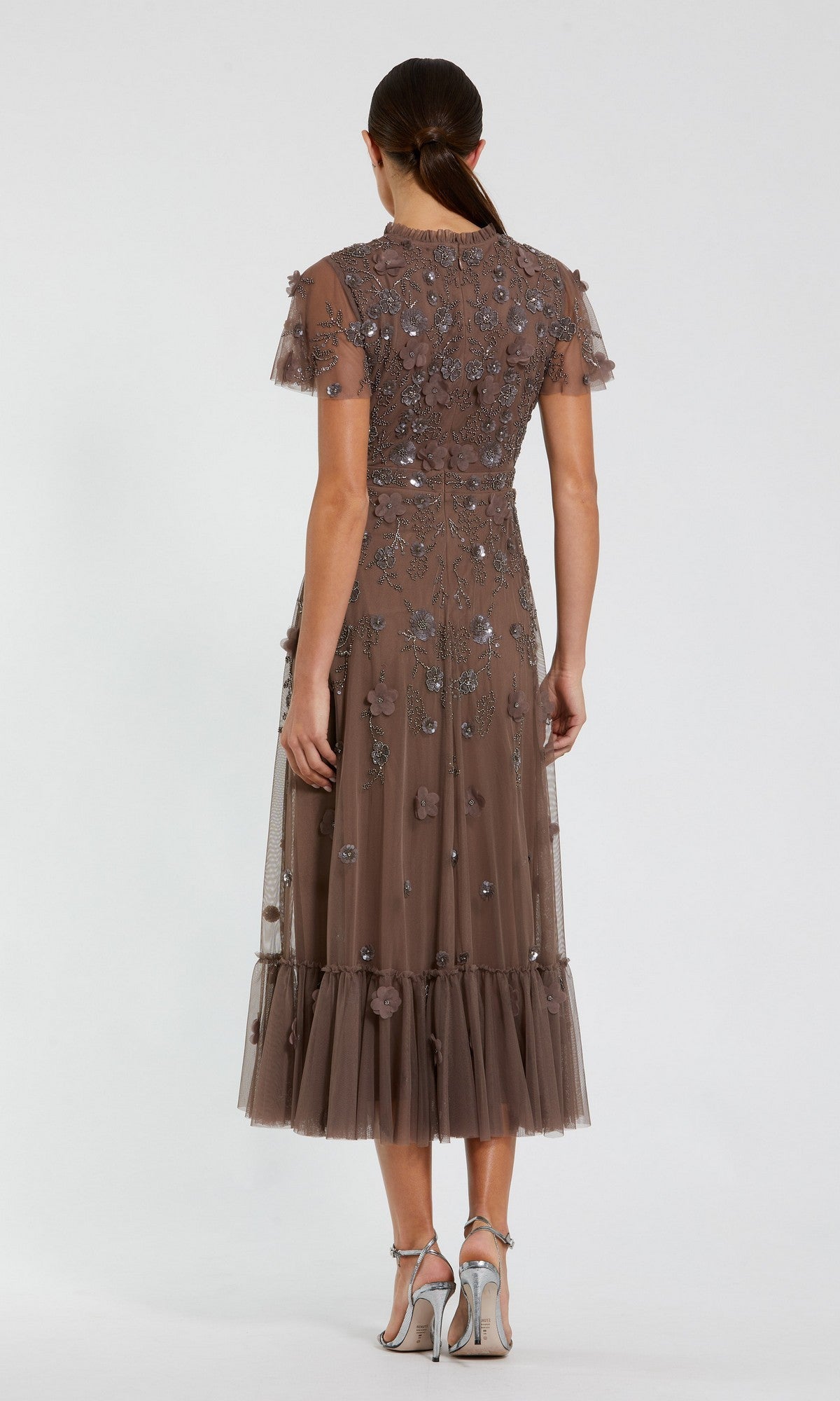Woman stands with her back to the camera in the Mac Duggal 9212 Floral Midi Wedding-Guest Dress, featuring floral embellishments, tulle details, and calf-length style, paired with silver high-heeled sandals.
